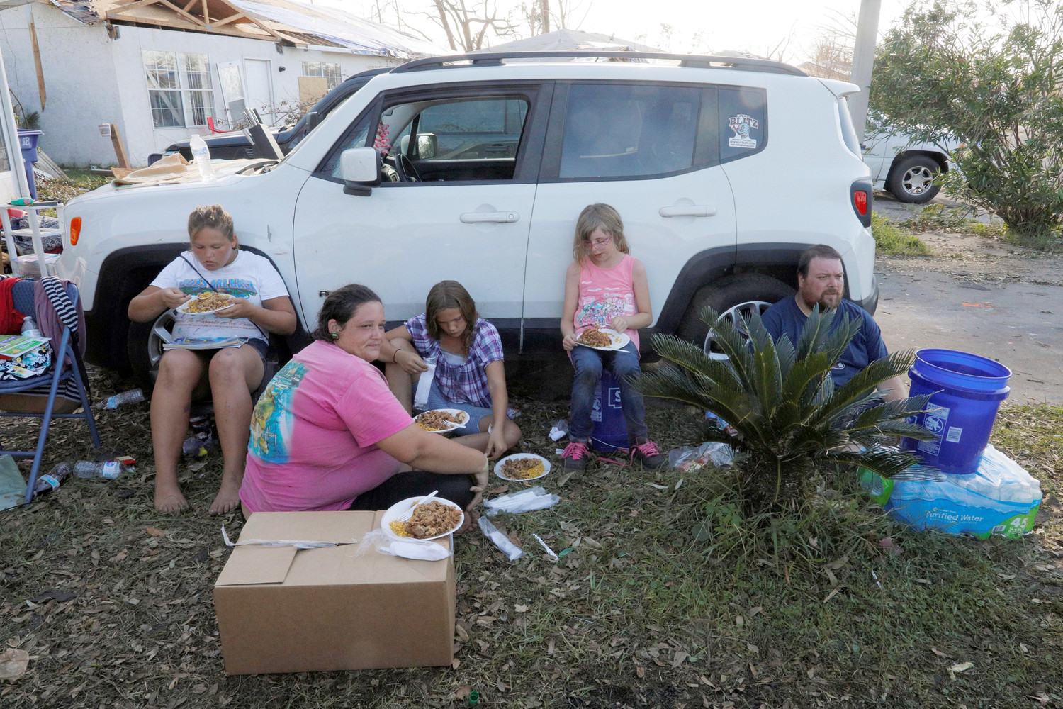 The Lachance family eats a hot meal prepared by Operation BBQ Relief and distributed by members of 50 Star Search and Rescue outside their damaged home Oct. 16 in the aftermath of Hurricane Michael in Panama City, Fla. The hurricane killed at least 16 people in Florida, most of them in the coastal county that took a direct hit from the storm, state emergency authorities said. That’s in addition to at least 10 deaths elsewhere across the South.